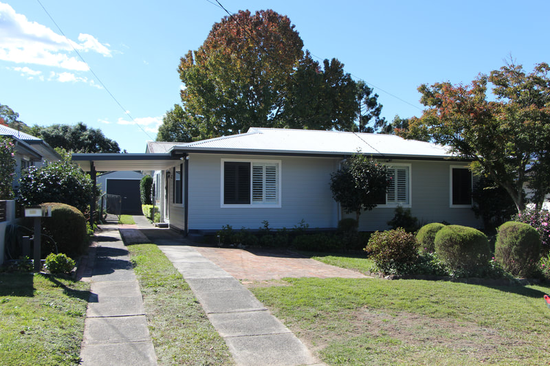 Newly painted exterior of a house: walls, window trims, facia at Lisarow.